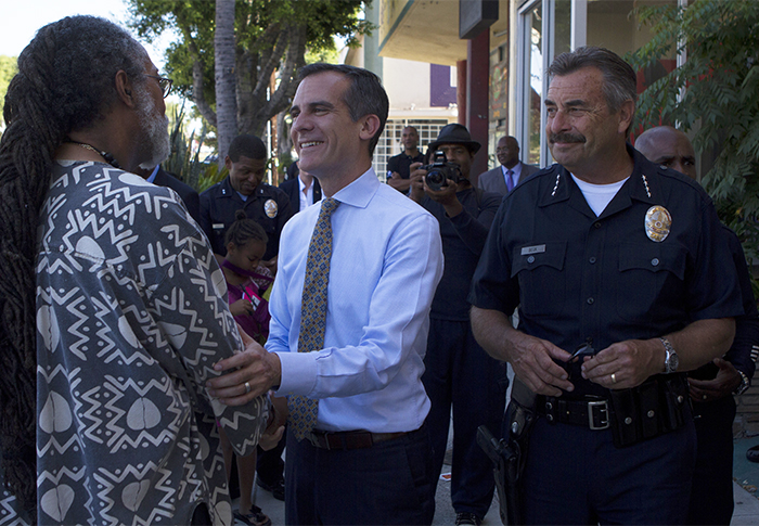 Mayor Eric Garcetti and Police Chief Charlie Beck talk with the Rev. C. Eziokwu Washington on the streets of Leimert Park in July during a visit to the community. The community is hoping a Metro rail station will be a spur to future economic growth for the area. (File photo by Gary McCarthy)